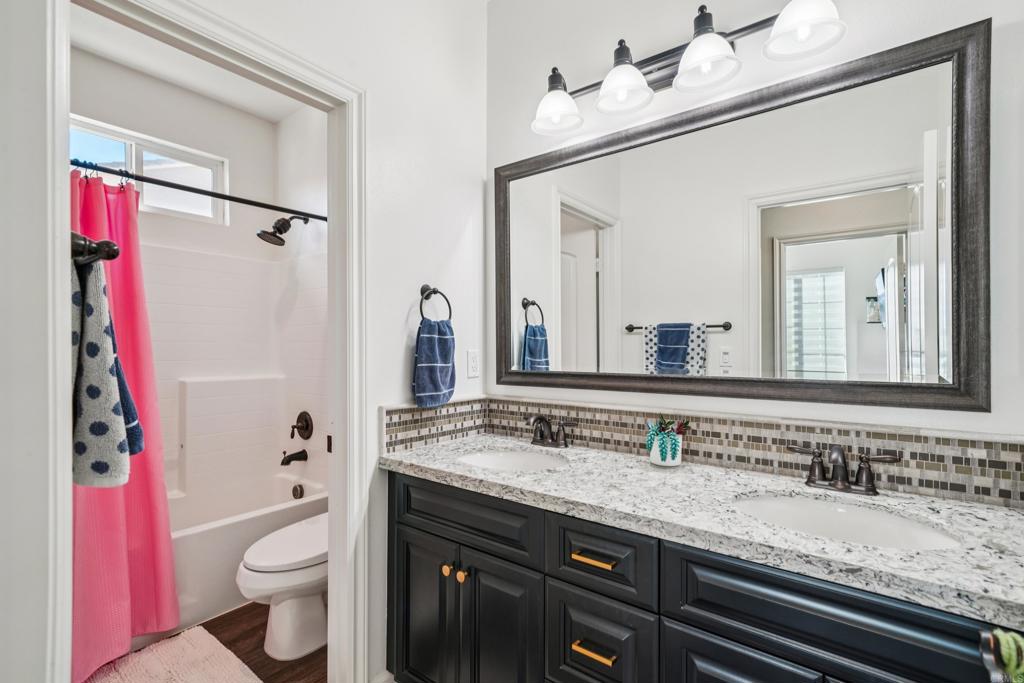33294 Barmetta Lane Temecula, CA 92592 - Photo 21 of 36 a bathroom with a granite countertop toilet sink and mirror
