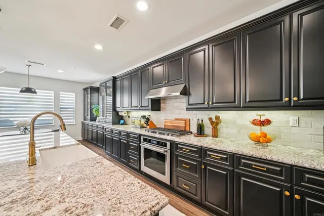 a kitchen with stainless steel appliances granite countertop a stove a sink dishwasher a microwave oven with granite countertops and cabinets