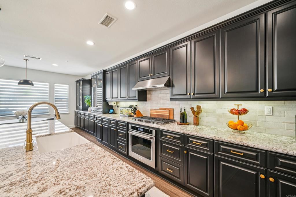 33294 Barmetta Lane Temecula, CA 92592 - Photo 9 of 36 a kitchen with stainless steel appliances granite countertop a stove a sink dishwasher a microwave oven with granite countertops and cabinets