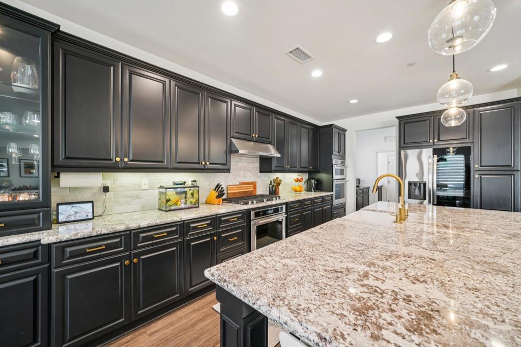 33294 Barmetta Lane Temecula, CA 92592 - Photo 10 of 36 a kitchen with granite countertop stainless steel appliances and wooden cabinets
