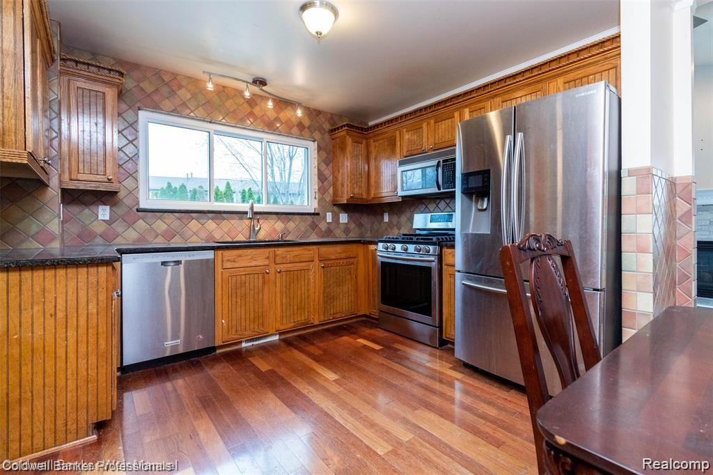 8263 Jeremy Road Belleville, MI 48111 - Photo 13 of 29 Stainless appliances and granite counters with backsplash