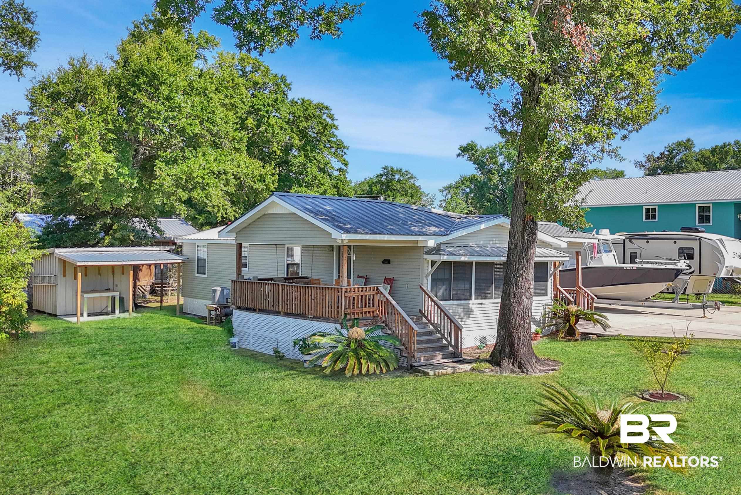 5392 Ornacor Avenue Orange Beach, AL 36561 - Photo 30 of 48 Back of property with a sunroom, a patio, and a lawn