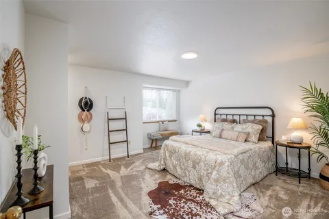 a bedroom with a large bed and potted plant