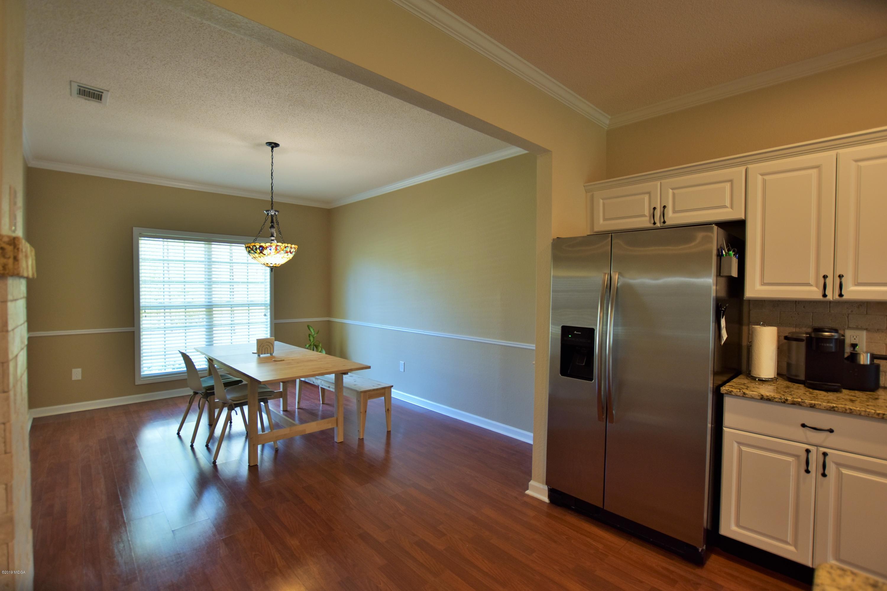 262 Ridge Point Way Macon, GA 31220 - Photo 12 of 27 a kitchen with stainless steel appliances granite countertop a refrigerator a stove and a dining table with wooden floor