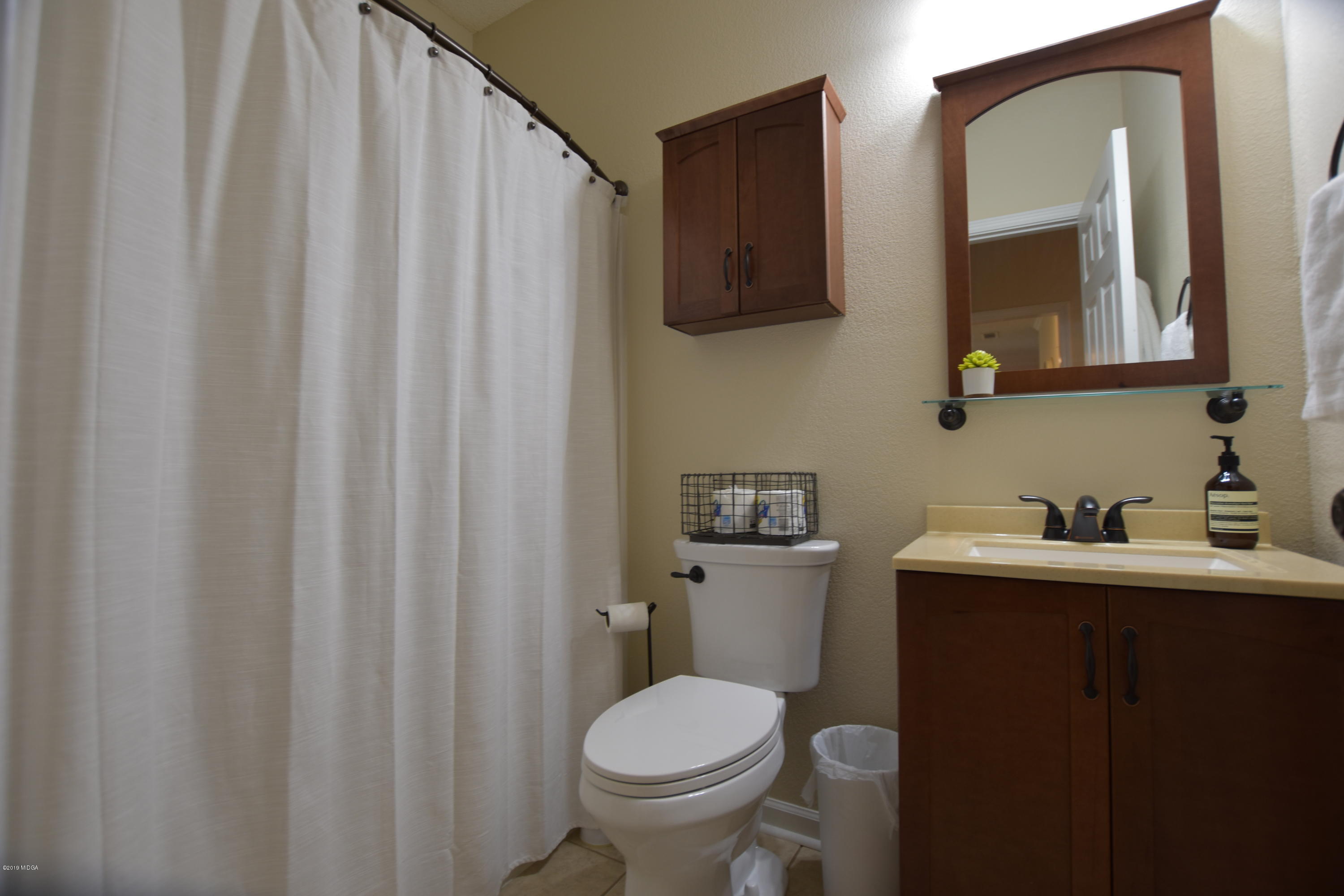 262 Ridge Point Way Macon, GA 31220 - Photo 20 of 27 a bathroom with a toilet a sink and mirror