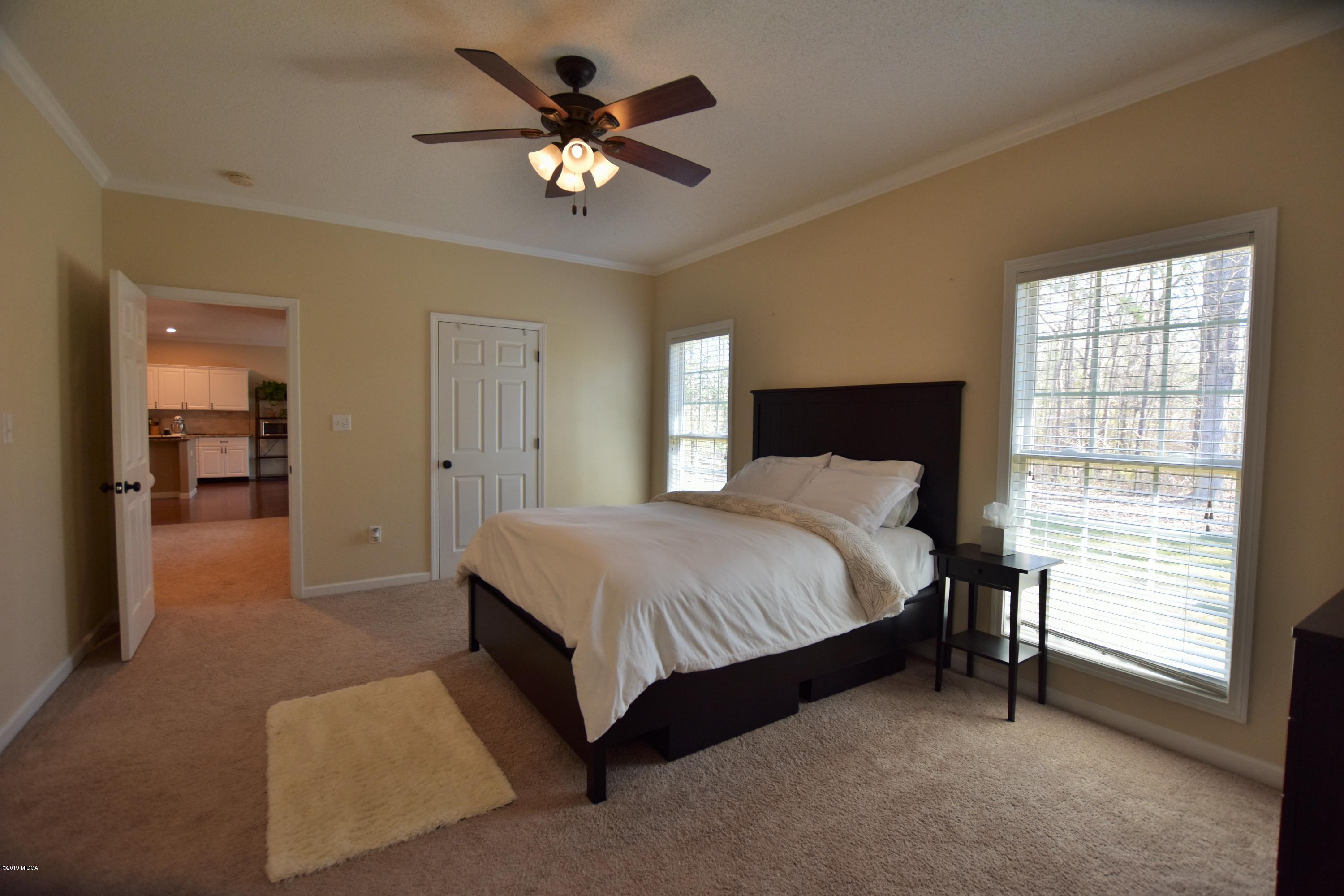 262 Ridge Point Way Macon, GA 31220 - Photo 21 of 27 a spacious bedroom with a bed and a chandelier