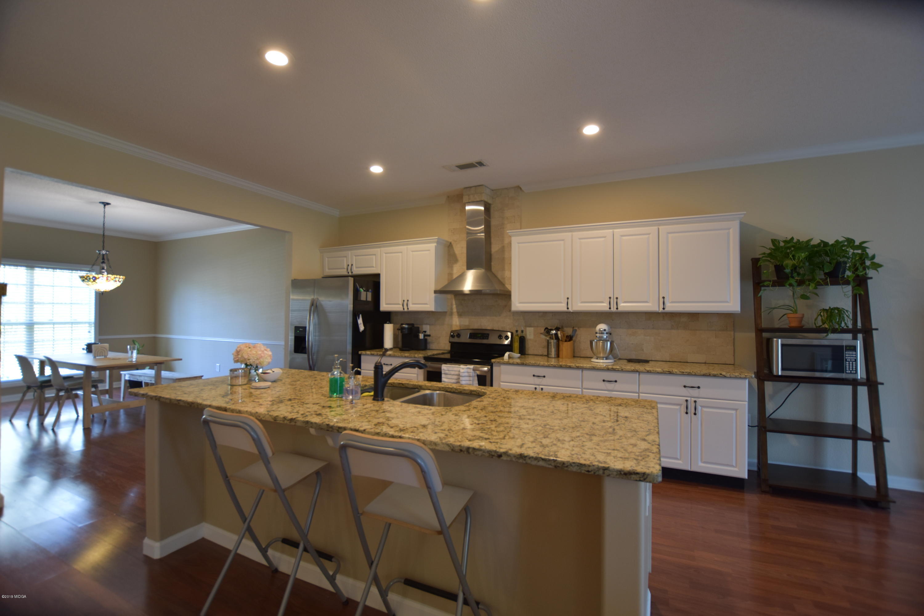 262 Ridge Point Way Macon, GA 31220 - Photo 7 of 27 a kitchen with a table chairs refrigerator and cabinets