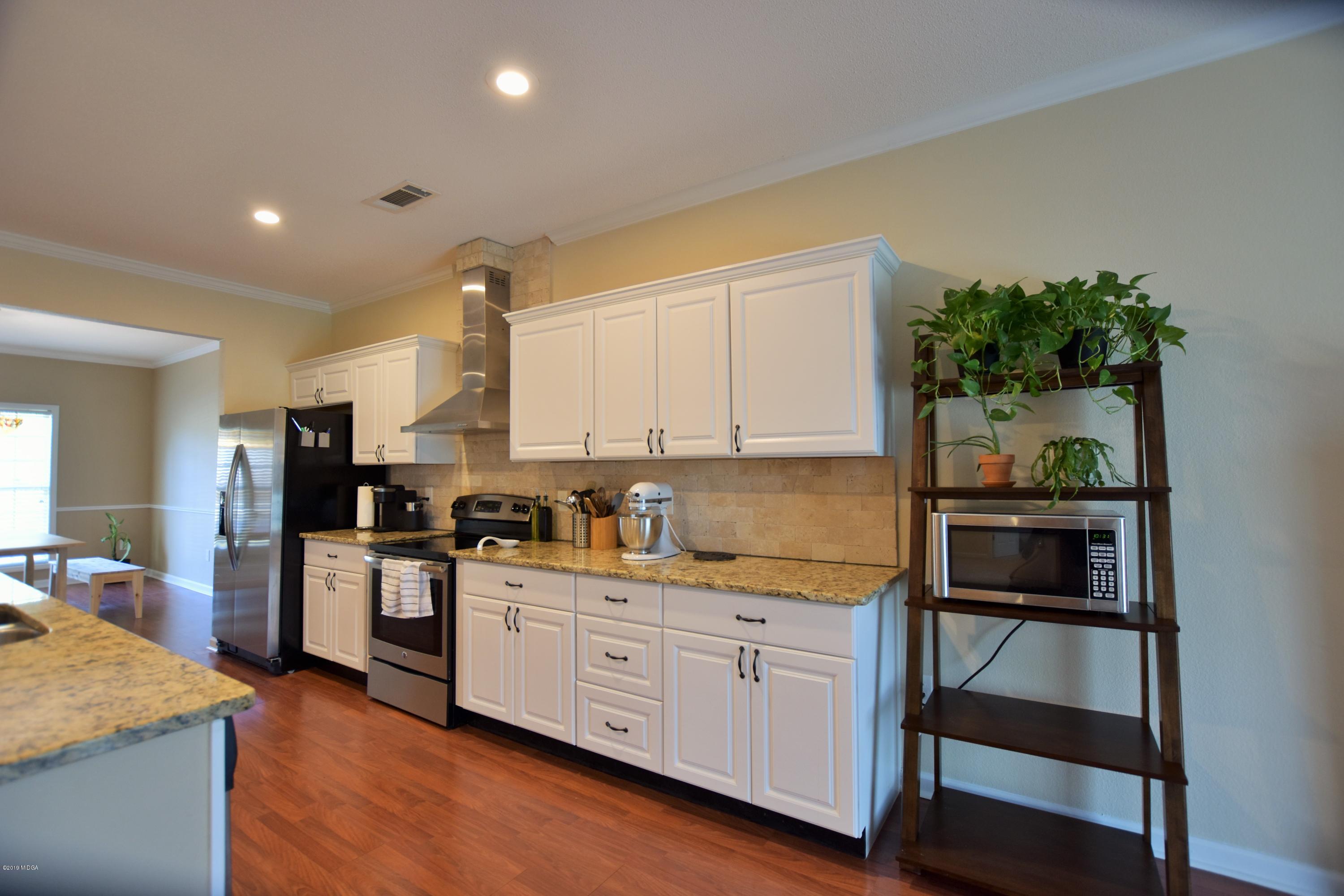 262 Ridge Point Way Macon, GA 31220 - Photo 9 of 27 a kitchen with white cabinets and appliances