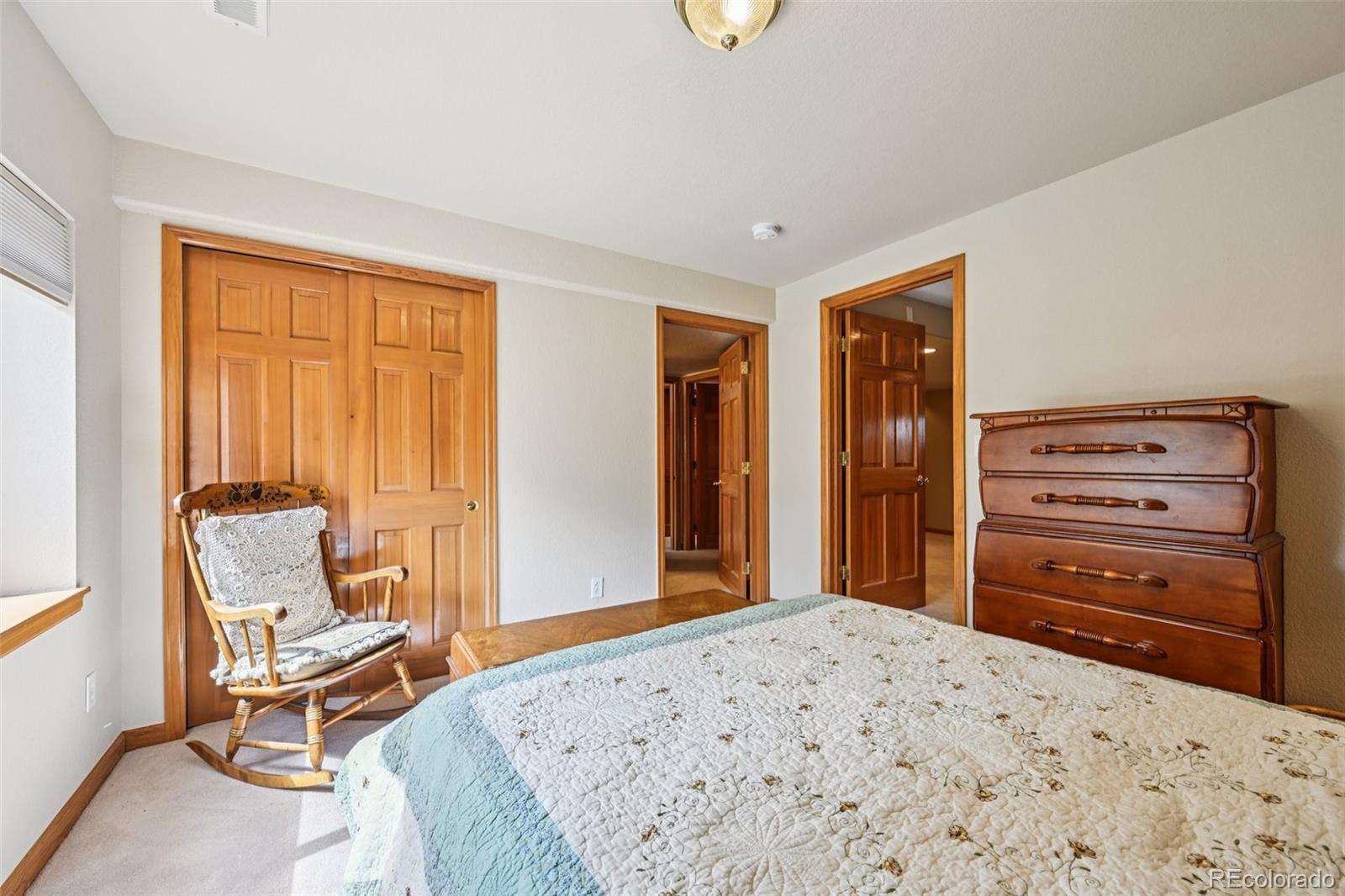 6060 Deframe Court Arvada, CO 80004 - Photo 30 of 45 a bedroom with a bed and chair