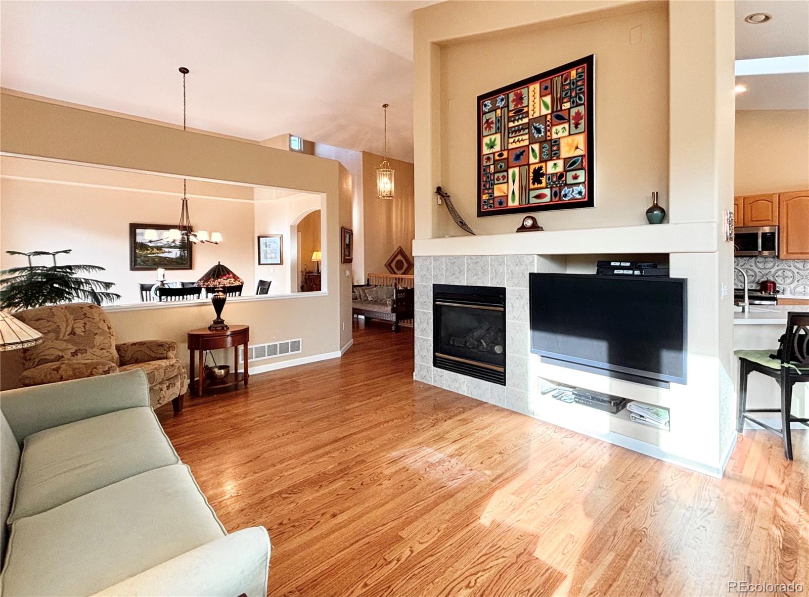 6060 Deframe Court Arvada, CO 80004 - Photo 8 of 45 a living room with furniture and a flat screen tv