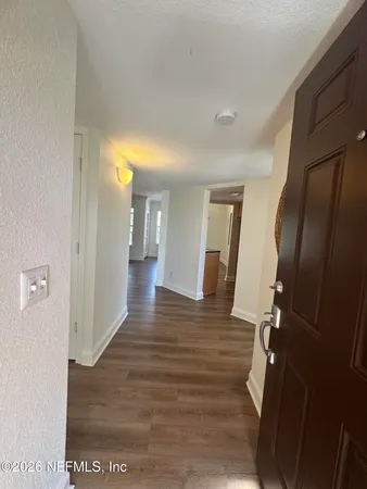 a view of a hallway with wooden floor