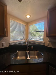 a view of a livingroom with wooden floor and a chandelier