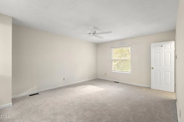 an empty room with a window and a ceiling fan