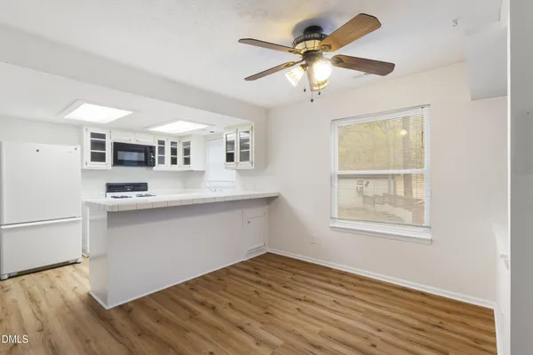 a kitchen with stainless steel appliances granite countertop a sink cabinets and wooden floor