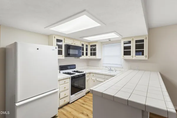 a kitchen with a stove a refrigerator and a sink
