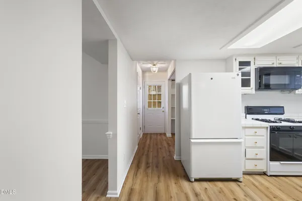 a kitchen with a refrigerator and a stove top oven