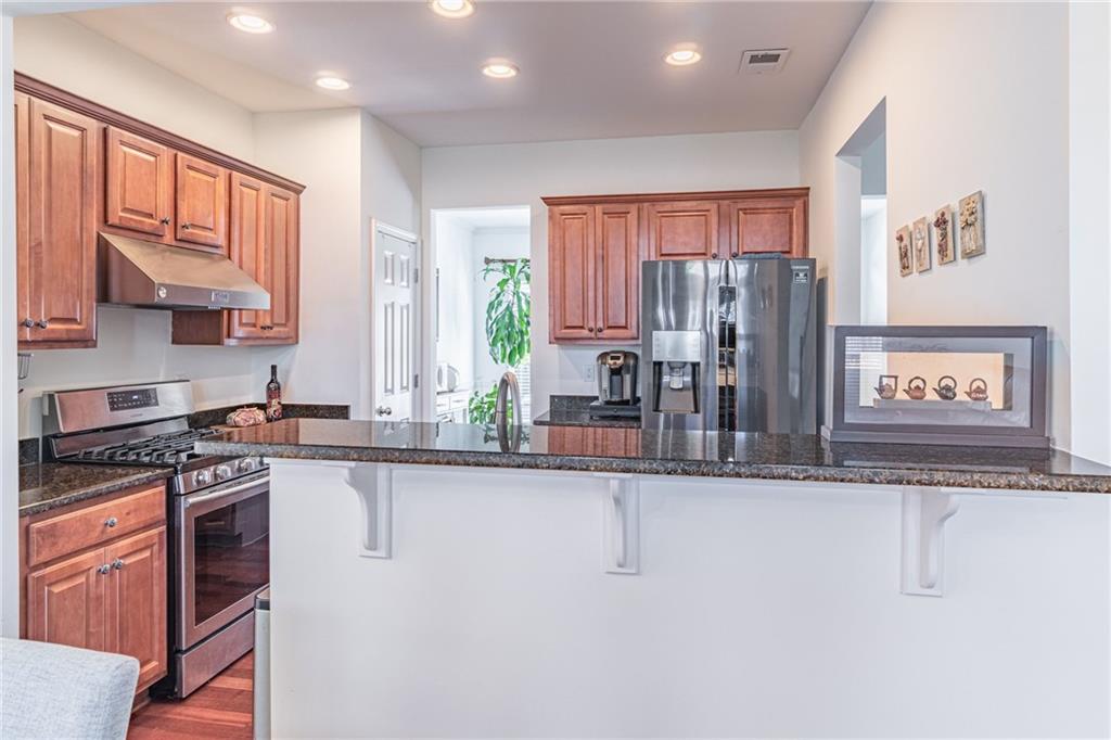 3487 Harvest Ridge Lane Northeast Buford, GA 30519 - Photo 12 of 34 a kitchen with stainless steel appliances granite countertop a stove a sink and a refrigerator