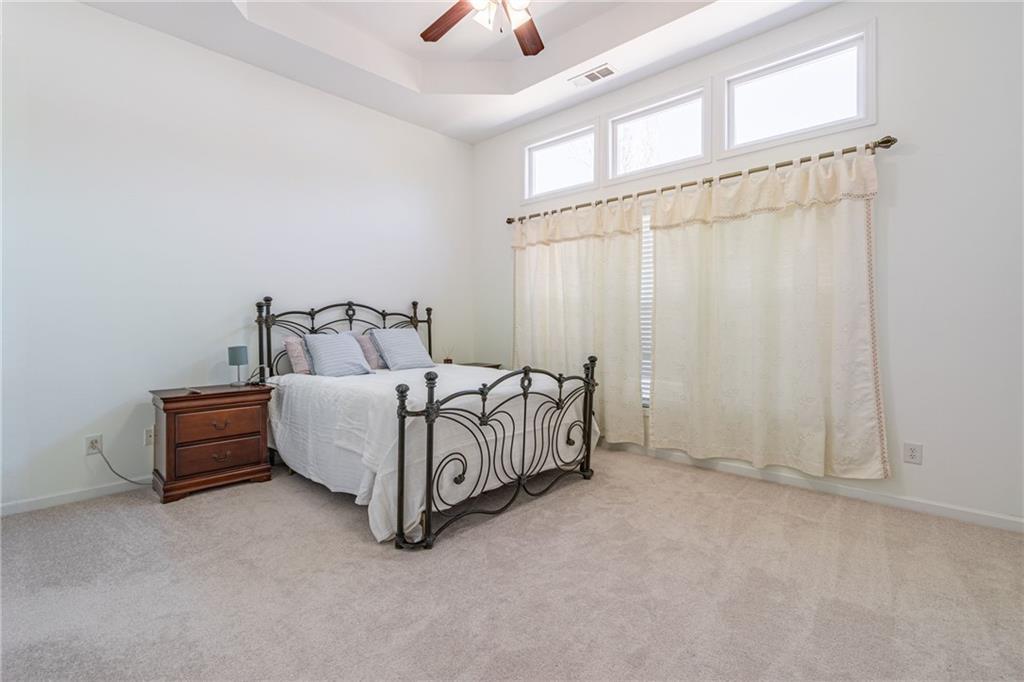 3487 Harvest Ridge Lane Northeast Buford, GA 30519 - Photo 18 of 34 a bed room with a bed and a chandelier fan