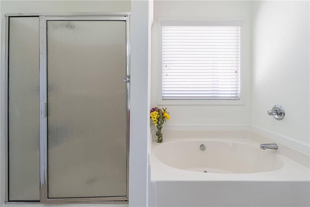 3487 Harvest Ridge Lane Northeast Buford, GA 30519 - Photo 21 of 34 a white bath tub with a shower