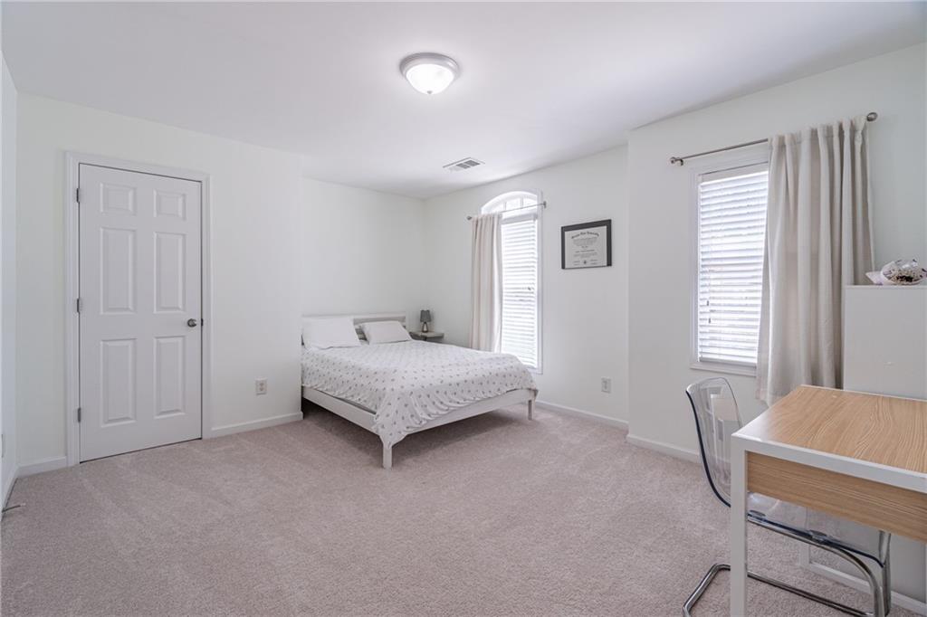 3487 Harvest Ridge Lane Northeast Buford, GA 30519 - Photo 24 of 34 a bedroom with a bed and wooden floor