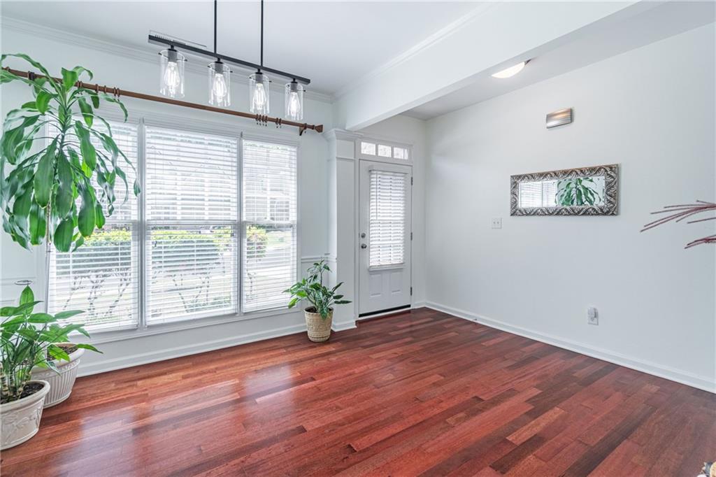 3487 Harvest Ridge Lane Northeast Buford, GA 30519 - Photo 5 of 34 a view of an empty room with wooden floor and a potted plant