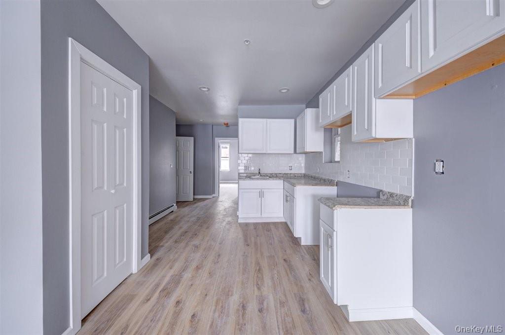 93 South Lander Street, Unit 2 Newburgh, NY 12550 - Photo 11 of 21 a kitchen with cabinets wooden floor and stainless steel appliances