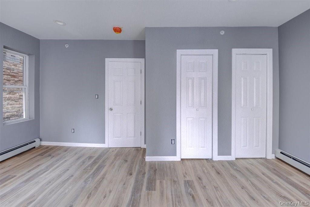 93 South Lander Street, Unit 2 Newburgh, NY 12550 - Photo 16 of 21 an empty room with wooden floor and windows
