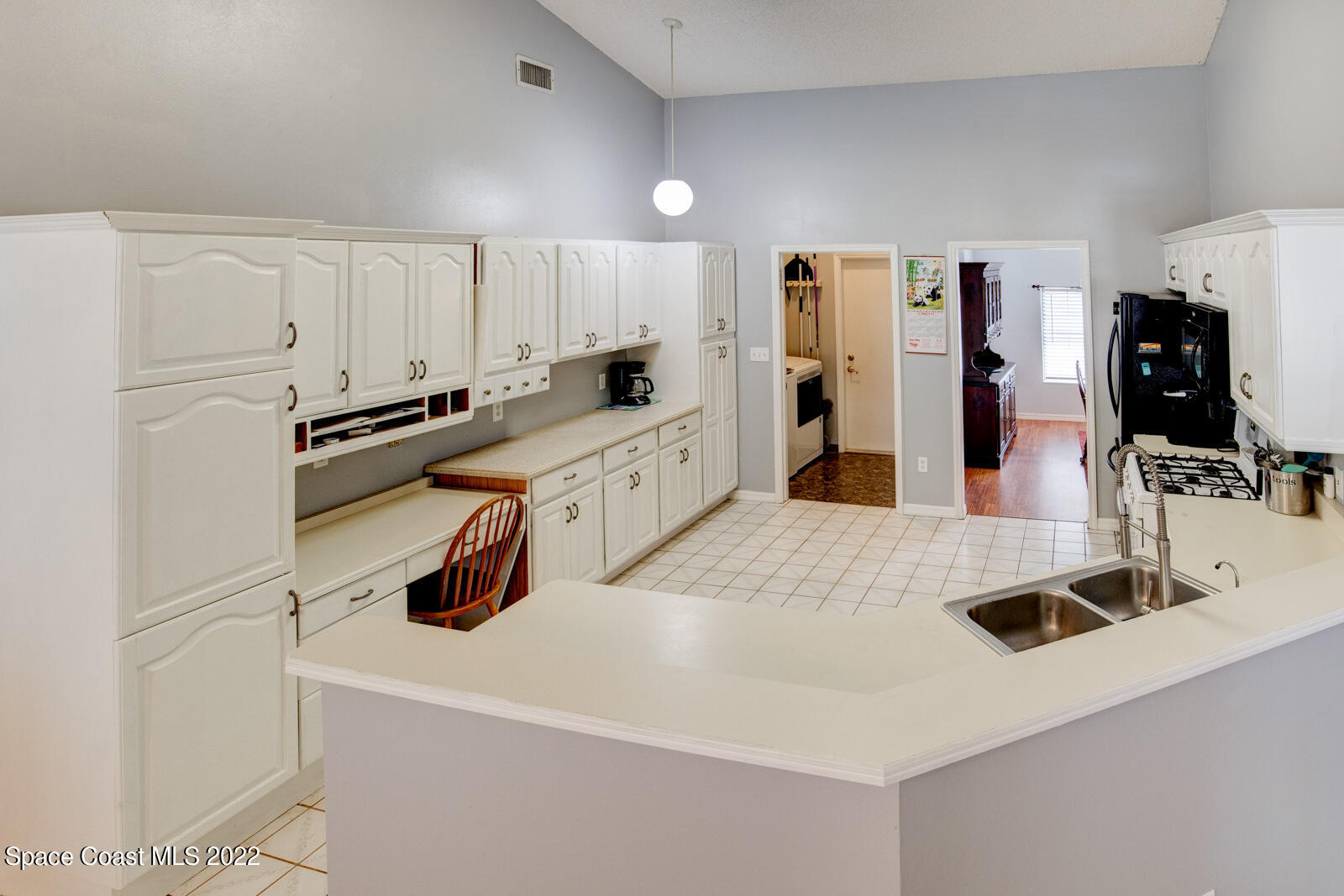 1250 North Carpenter Road Titusville, FL 32796 - Photo 15 of 52 a kitchen with white cabinets and appliances