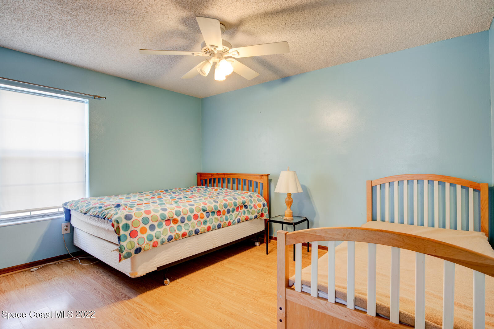 1250 North Carpenter Road Titusville, FL 32796 - Photo 30 of 52 a bedroom with two beds and a chandelier