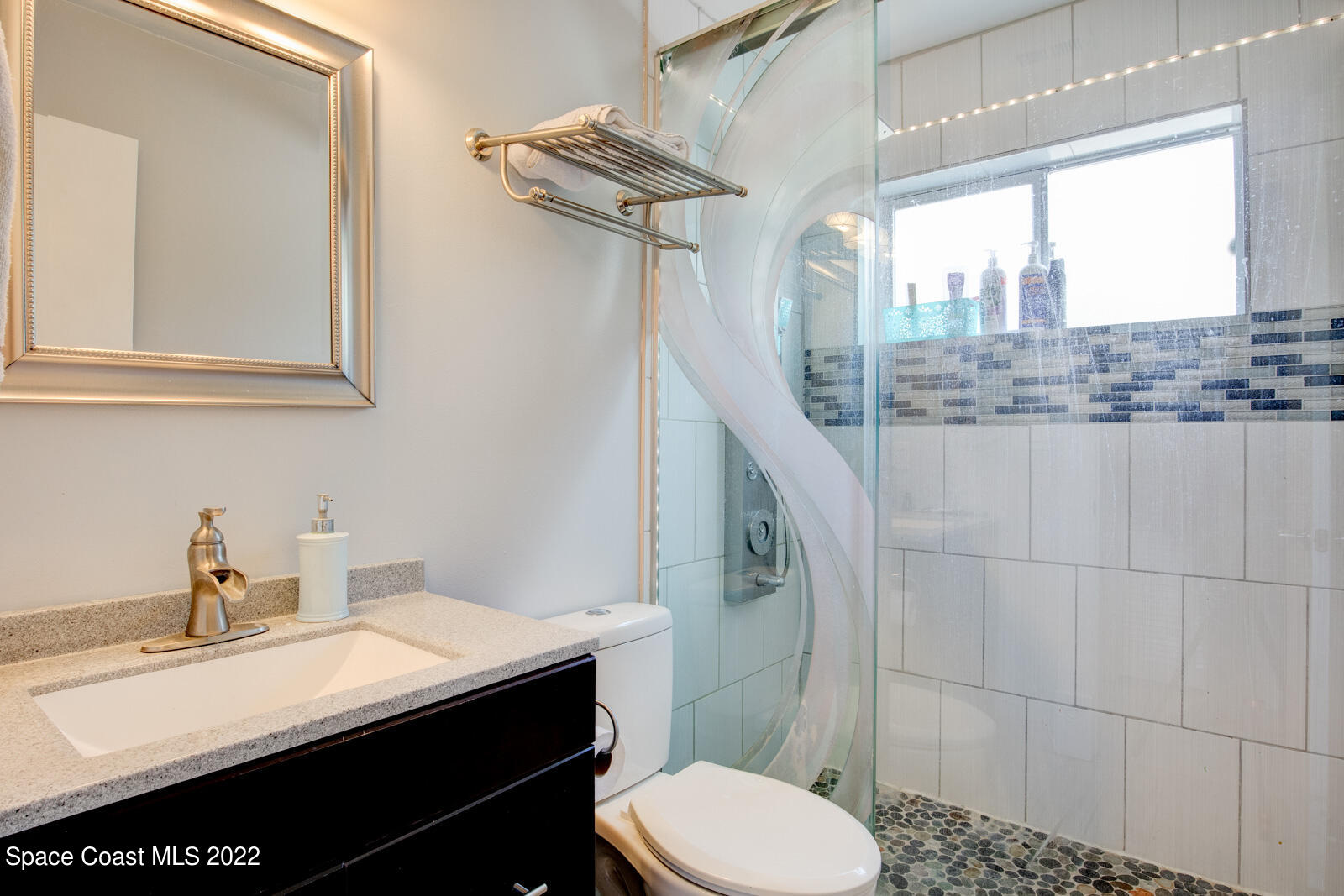 1250 North Carpenter Road Titusville, FL 32796 - Photo 34 of 52 a bathroom with a sink a toilet a mirror and shower