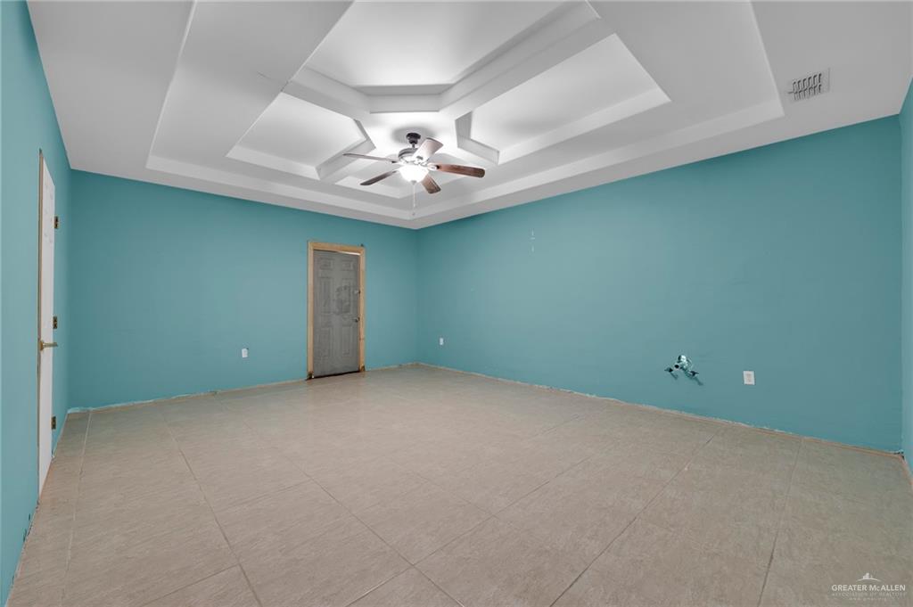 26821 Brushline Road Edinburg, TX 78542 - Photo 4 of 11 an empty room with a chandelier fan and a fireplace