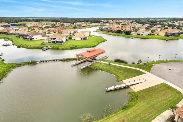an aerial view of residential houses with outdoor space and lake view