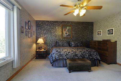 284 Paddock Circle Glendale Heights, IL 60139 - Photo 6 of 11 a bedroom with a bed and a chandelier
