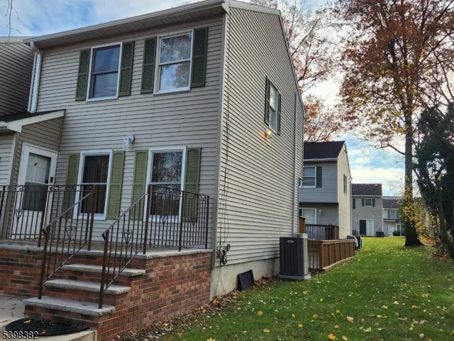 a view of a house with a yard and large tree