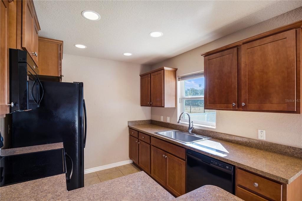 4495 Southeast 150th Street Summerfield, FL 34491 - Photo 15 of 76 a kitchen with stainless steel appliances granite countertop a refrigerator and a sink