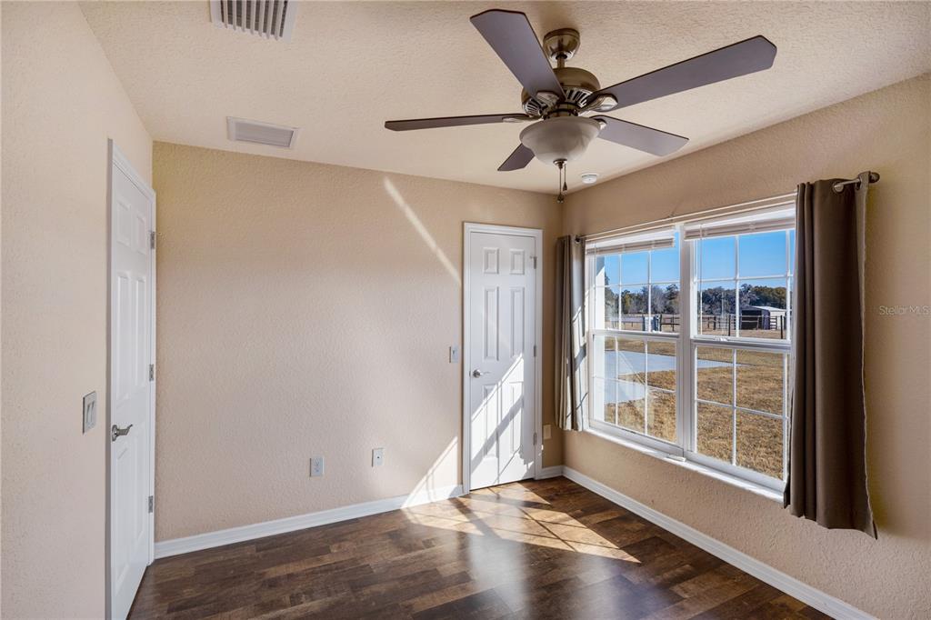 4495 Southeast 150th Street Summerfield, FL 34491 - Photo 19 of 76 an empty room with wooden floor fan and windows