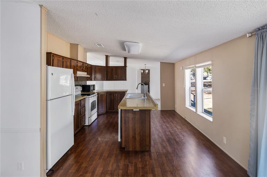 4495 Southeast 150th Street Summerfield, FL 34491 - Photo 60 of 76 a kitchen with stainless steel appliances a refrigerator a sink dishwasher a stove and white countertops with wooden floor