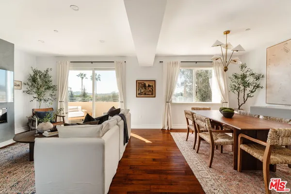 a living room with furniture wooden floor and a chandelier