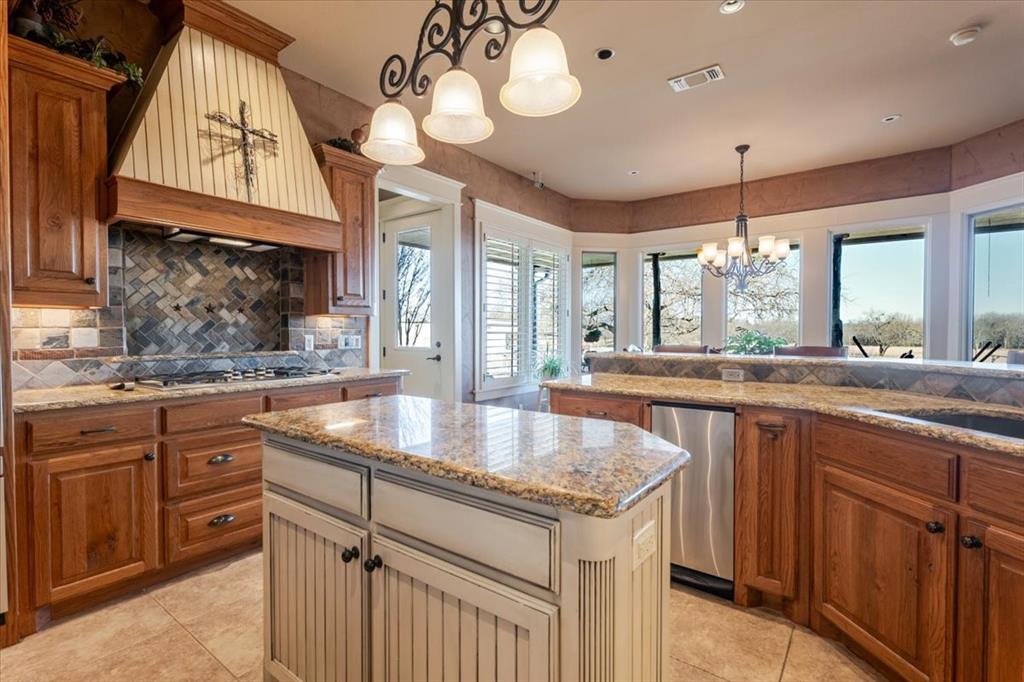 11918 Riek Road Krum, TX 76249 - Photo 15 of 40 a kitchen with granite countertop a sink a counter space and a window