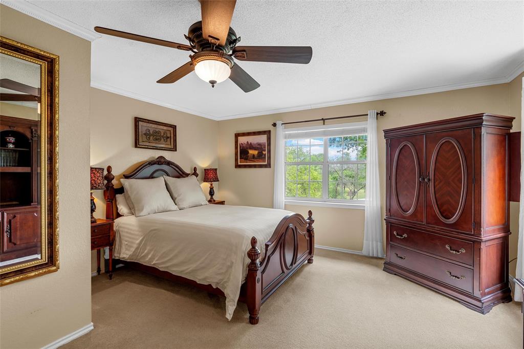 743 Stillwater Road Waco, TX 76708 - Photo 24 of 40 a bedroom with a bed and a chandelier
