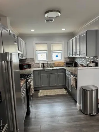 a kitchen with granite countertop a sink stainless steel appliances and cabinets