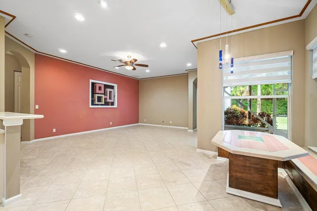 a view of a white house with a large pool and a yard with palm trees