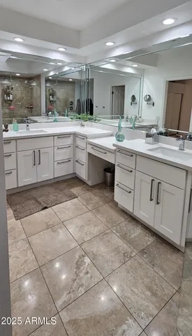 a large white kitchen with a sink and cabinets
