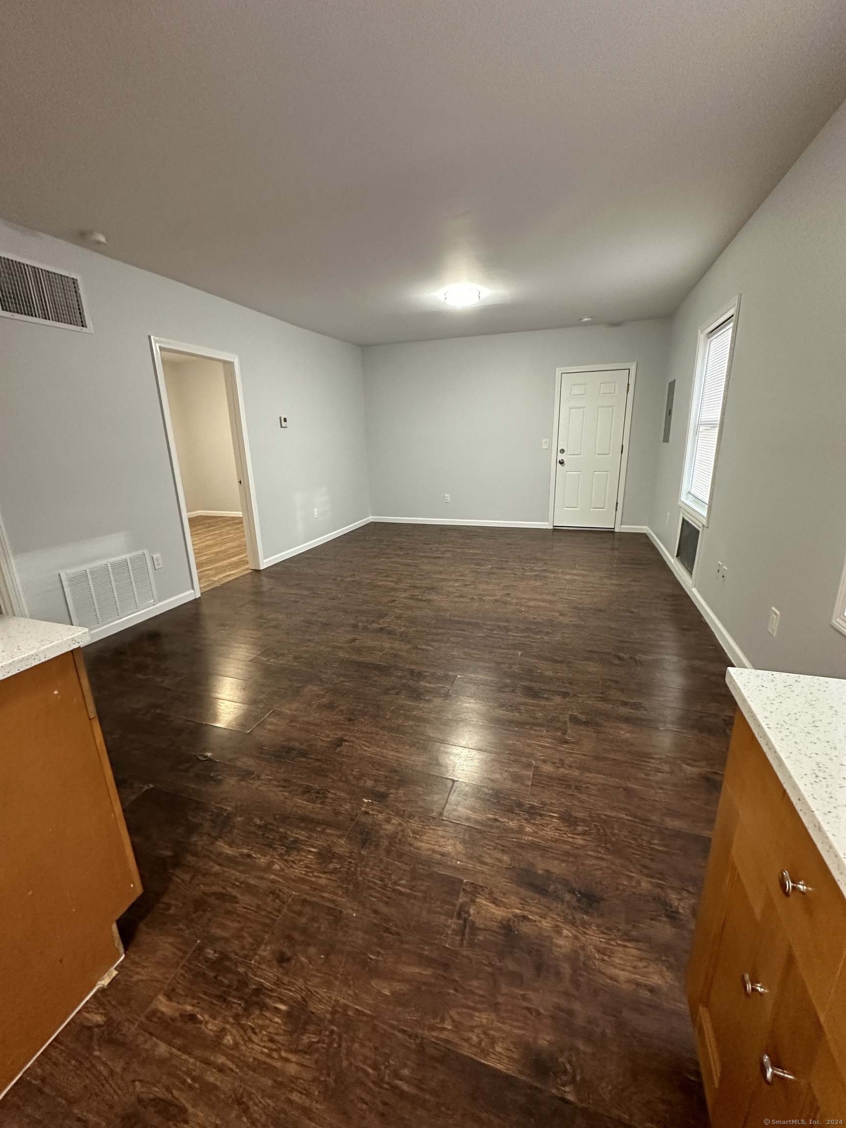 en empty room with window and wooden floor