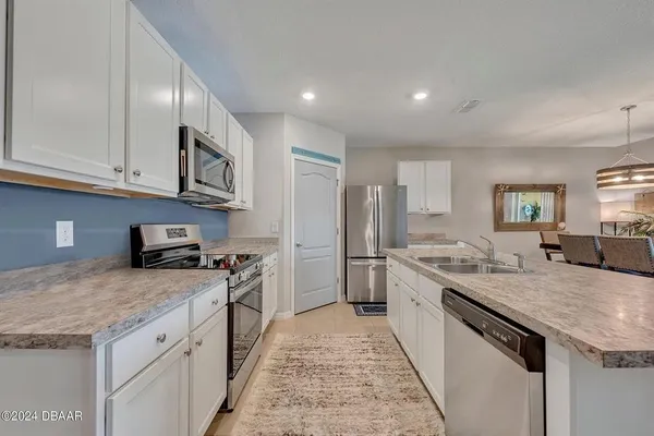 a kitchen with kitchen island a sink stove and refrigerator