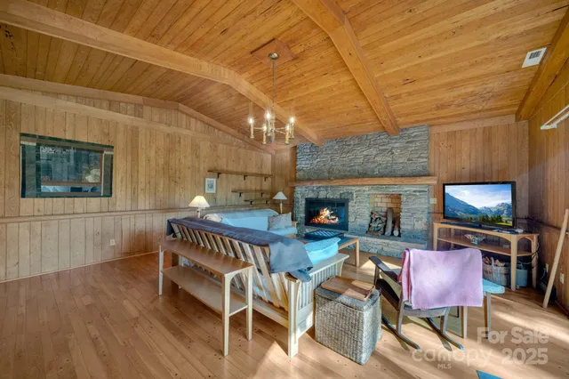 a living room with furniture a flat screen tv and a large window