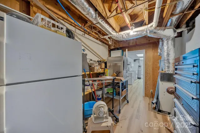 a kitchen with a sink a counter top space stainless steel appliances and wooden floor
