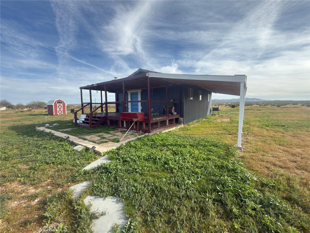 1320 Jacks Ranch Road Ridgecrest, CA 93555 - Photo 9 of 18 a view of a house with a yard and sitting area