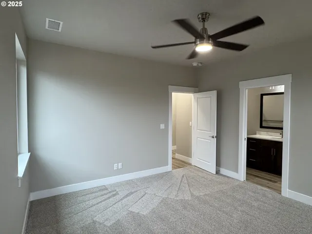 an empty room with closet and a chandelier fan