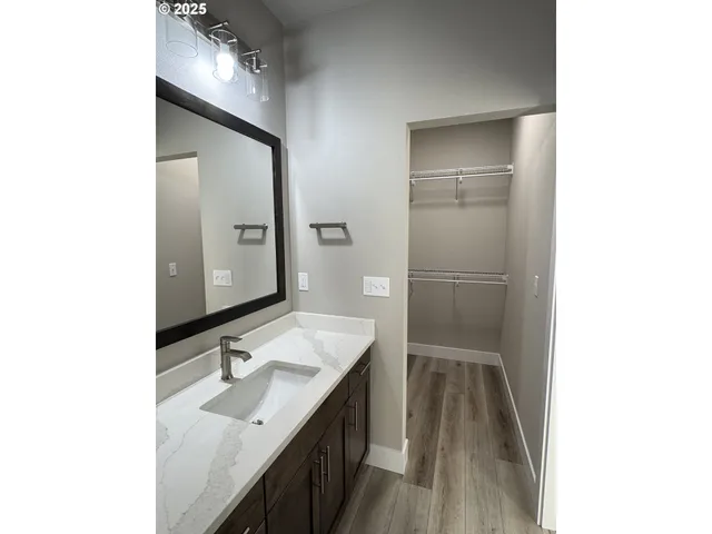 a bathroom with a granite countertop sink a mirror and a shower